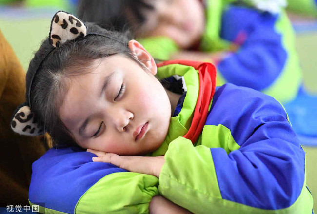 2018年3月21日，安徽亳州，谯城区风华桐乡路小学的老师在教孩子们正确的睡觉姿势。
