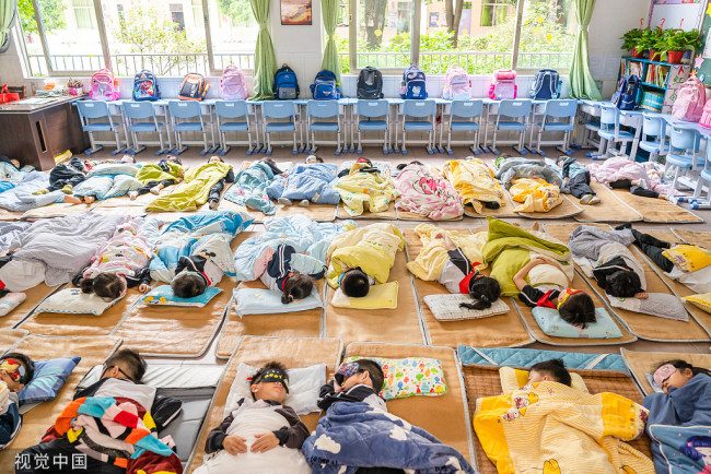 2021年11月3日，广东省佛山市顺德区龙江镇为深入贯彻落实双减政策，保障学生身心健康，镇17所学校全部实现学生午休躺睡。龙江城区中心小学学生们正在课室内午休。